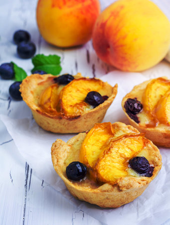 Homemade tartlets with peach and blueberriesの写真素材