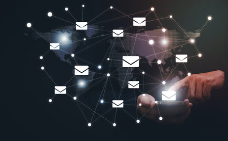 Businessman holding smartphone with communication icons, letter icon, email icons, and newsletter...