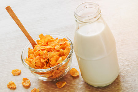 Bowl of cornflake and milk bottleの写真素材