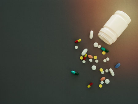 pills and pill bottle on gray background. top view.の写真素材