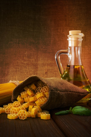 Pasta, spaghetti with basil and oil on wooden backgroundの写真素材