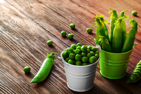 hearthy fresh green peas and pods in a bucket on wood table.の写真素材
