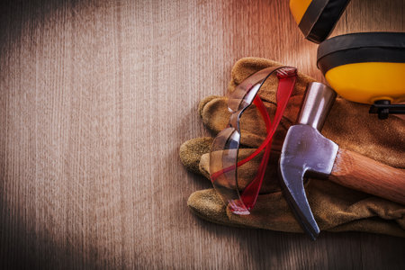 Headphones claw hammer leather safety gloves and protective glasses.