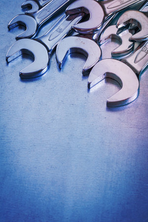 Vertical copy space view of stainless spanner wrenches on metallic background construction conceptの写真素材