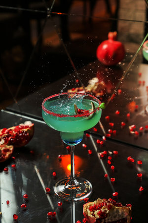 blue cocktail with pomegranate and syrup side viewの写真素材