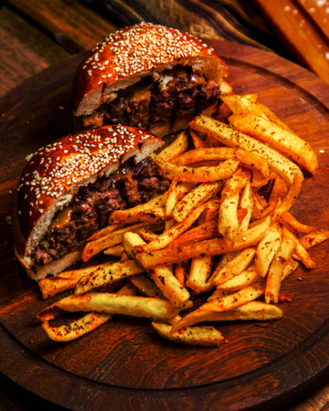 meat burger on wooden board french fries side viewの写真素材