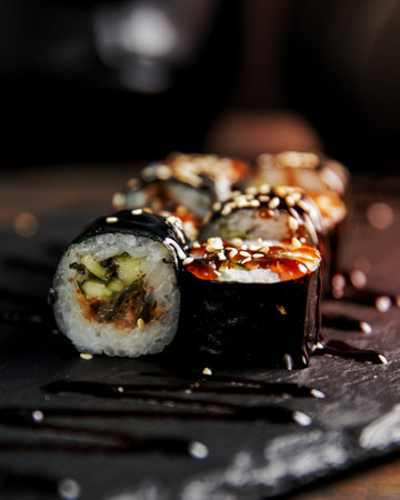 maki roll with cucumber served with sauce and sesame seedsの写真素材