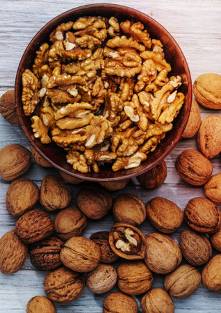 top view of walnuts in a bowl on rustic background