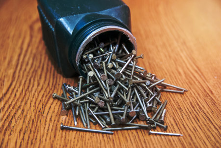 Box of screws open on wooden desk backgroundの写真素材