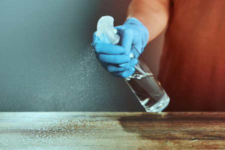 Horizontal shot of Hands in medical gloves treat the table with a sanitizer.の写真素材