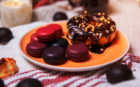 colorful Christmas sweets and hot drinks on the holiday table near the Christmas treeの写真素材