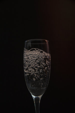 Pour water into the glass on a black background.の写真素材