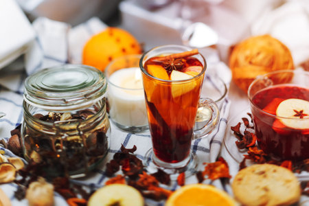 cup of hot mulled wine and a delicious cup of grog among the many delicious detail  on white checkered tableclothの写真素材