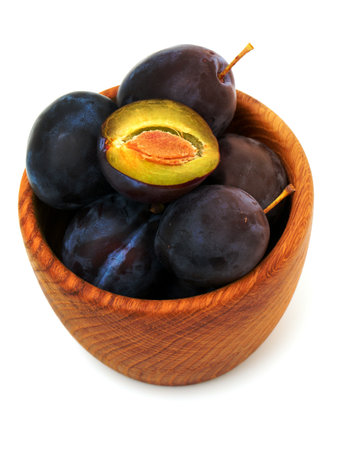 plums in a wooden bowlの写真素材