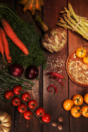 an abundance of vegetables and spices closeup on wooden table tomatoes, pumpkins, carrot, onion, pepper and otherの写真素材