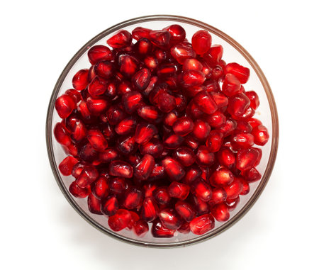 pomegranate in bowl isolated on whiteの写真素材