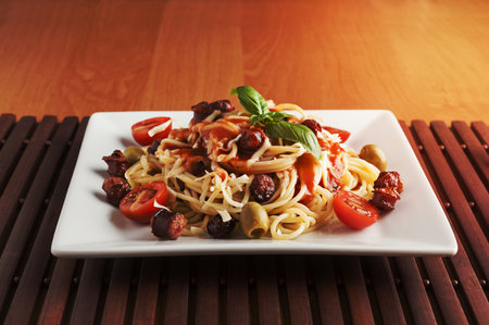 plate of spaghetti with tomato and olivesの写真素材