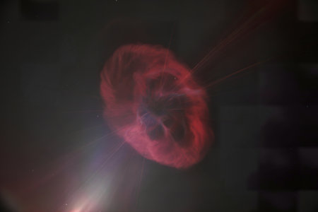 a single, luminous crimson nebula suspended against a stark black void
