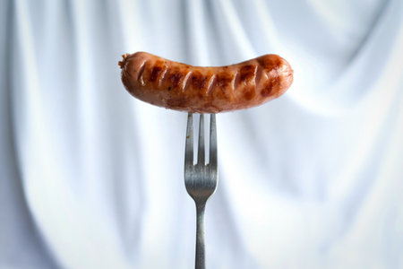 grilled sausage skewered on a forkの写真素材