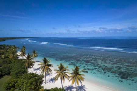 A photograph showcasing a pristine, white-sand beach curving gently along turquoise waters