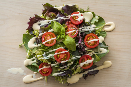 A photo of a fresh salad with herbs and sliced cherry tomatoesの写真素材