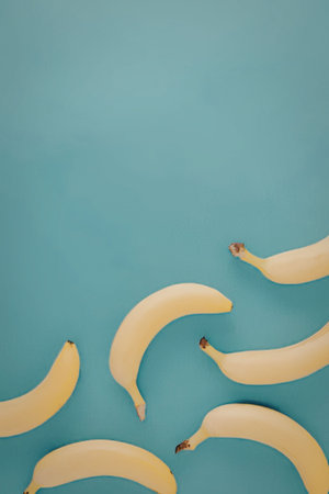A group of yellow bananas on a light blue backgroundの写真素材