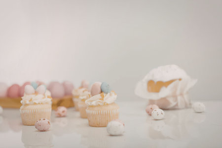 A visually appealing arrangement of Easter-themed cupcakes and eggs on a white surface.