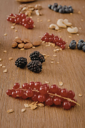 A selection of fresh berries and nuts arranged on a wooden surfaceの写真素材