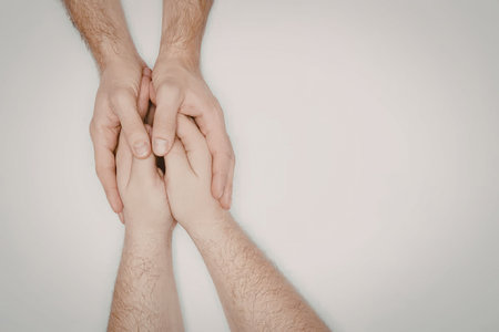 An image of two hands holding each other, symbolizing support, care, and connection.