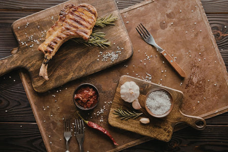 Grilled meat on wooden cutting boards with herbs and spices.の写真素材