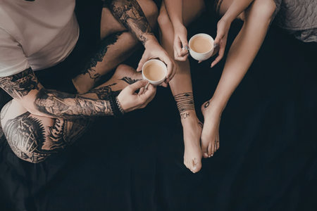 An image of people sitting with tattoos and drinking coffee