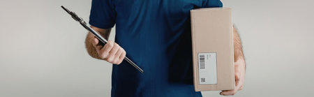 A person in a blue shirt holding a clipboard and a cardboard box