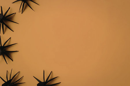 An orange background with several black starburst shapes in the top left cornerの写真素材