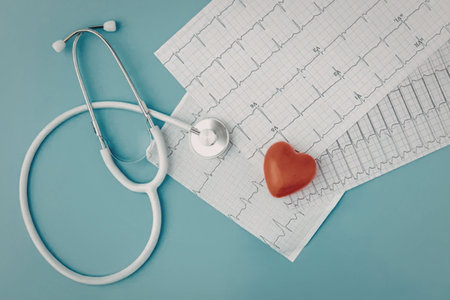 A stethoscope, a red heart, and an ECG paper on a blue background.