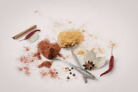 A collection of various spices and herbs, including chili peppers, cinnamon, and powder spices,...