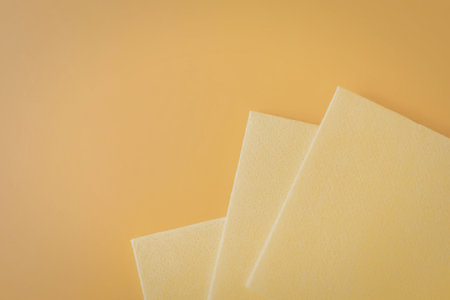 Three yellow squares are placed on an orange background, with the squares overlapping each other.