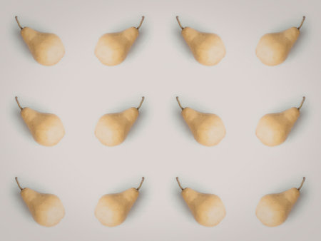An image of multiple yellow pears arranged in rows on a white background.