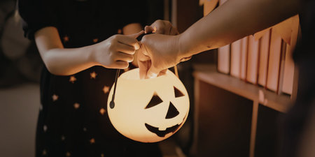 A person holding a glowing pumpkin lanternの写真素材