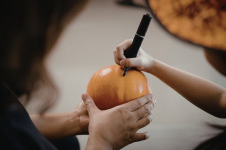 A person helping to carve a pumpkinの写真素材