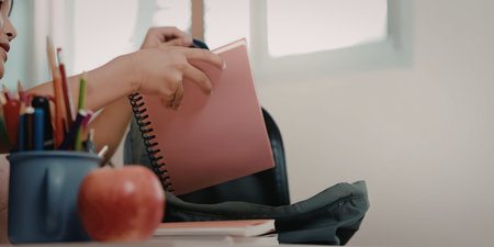A person sitting at a desk with school supplies