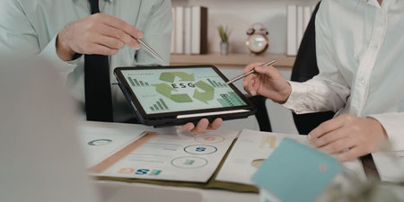 Business people analyzing green data on tablet