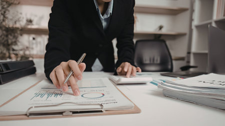 Businesswoman analyzing graphs and reports