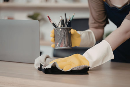 Cleaning the office desk with glovesの写真素材