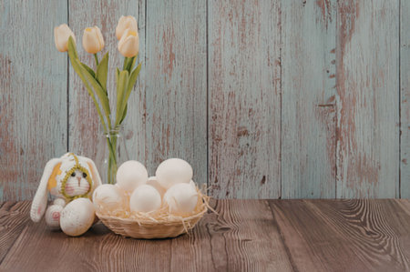 Easter eggs and tulips on wooden table