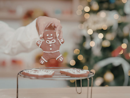 Hand decorating a gingerbread man cookie