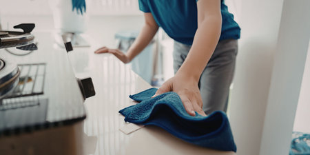 Person cleaning a surface with blue cloth