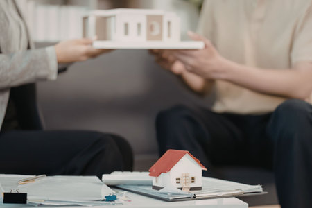 Real estate agents handing over house model