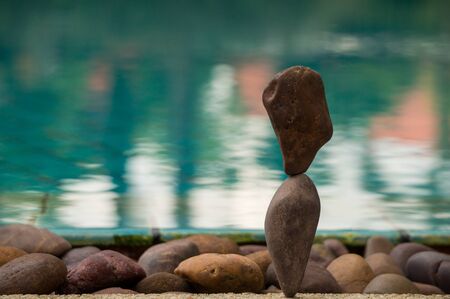 Rock balancing with a pool in the backgroundの写真素材