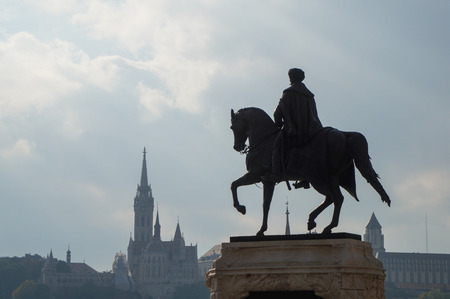 Horseman statue with church spire in the backgroundの写真素材
