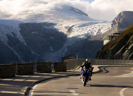 Salzburg, Austria - 30.09.2018: A motorcyclist driving on the Grossglockner high alpine road in Austriaの写真素材